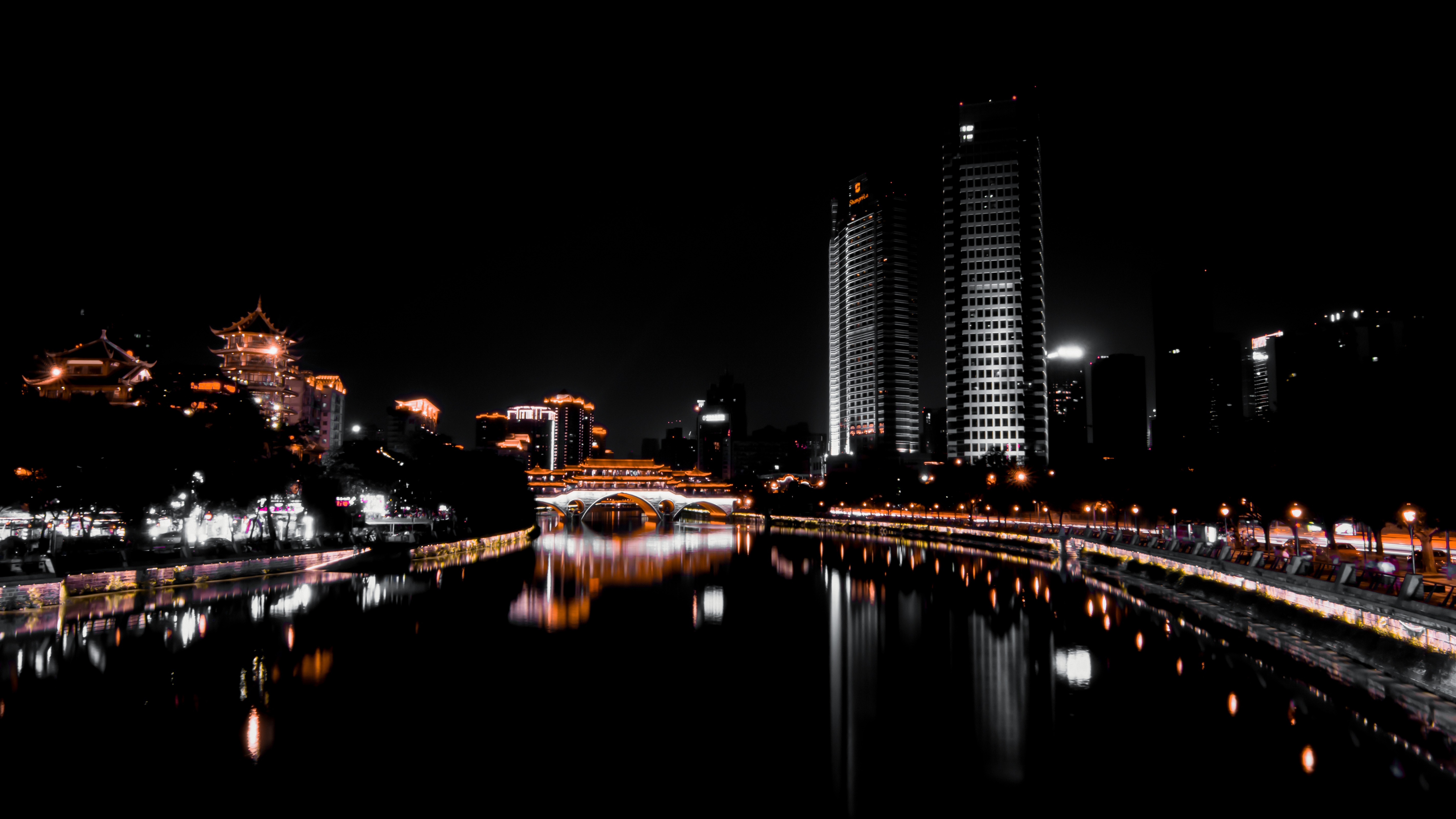 Chengdu night landscape showing traditional pavilions and modern towers reflecting on the tranquil Jin River.